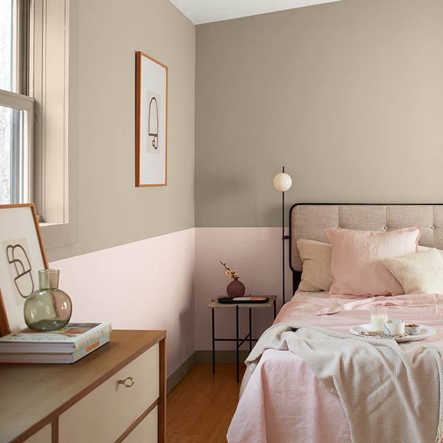 Pretty two-tone taupe and pink painted walls are the perfect backdrop for a comfy bed with soft pink bedding and pillows, and a two-toned wood dresser. Pretty two-tone taupe and pink painted walls are the perfect backdrop for a comfy bed with soft pink bedding and pillows, and a two-toned wood dresser.