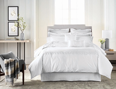 The palest gray walls flatter a bedroom with fluffy white bedding. The palest gray walls flatter a bedroom with fluffy white bedding.