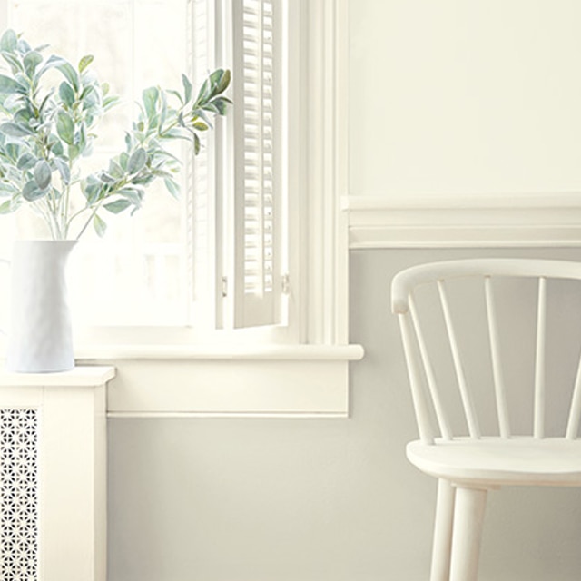Varying shades of white paint colors on walls, trim, and wainscoting, and a white chair by window. Varying shades of white paint colors on walls, trim, and wainscoting, and a white chair by window.