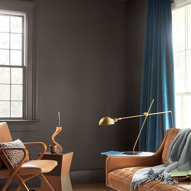 A rich charcoal-brown painted living room space with contemporary furnishings and Teal drapes. A rich charcoal-brown painted living room space with contemporary furnishings and Teal drapes.