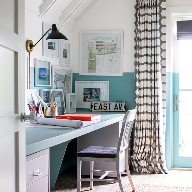 A cheerful home office with white painted upper walls, a vaulted ceiling with beams, and blue painted lower walls and desktop. A cheerful home office with white painted upper walls, a vaulted ceiling with beams, and blue painted lower walls and desktop.