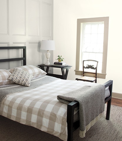 Relaxing bedroom with gray wainscoting behind black bed with gray and white checkered bedding. Relaxing bedroom with gray wainscoting behind black bed with gray and white checkered bedding.