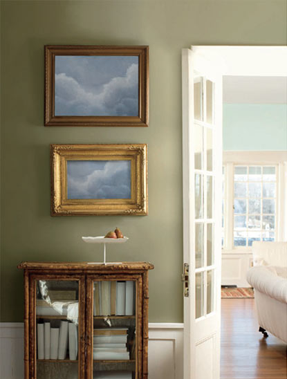 A soft, neutral green accent wall framed by a wooden console A soft, neutral green accent wall framed by a wooden console