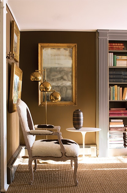 An animal print-upholstered chair, built-in bookcase in pale gray Nightingale AF-670, and walls painted in Carob AF-160. An animal print-upholstered chair, built-in bookcase in pale gray Nightingale AF-670, and walls painted in Carob AF-160.