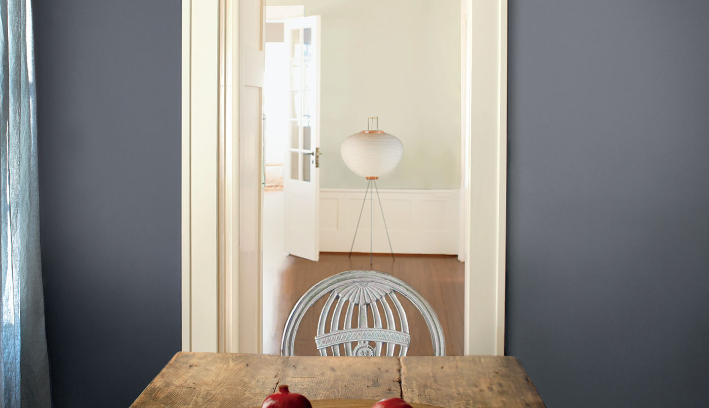 Rustic plank table with gray-blue wall and pomegranates