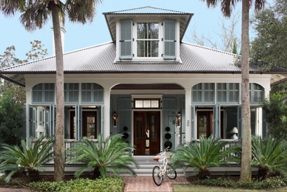 Light blue Key West-style home with front porch in tropical landscape. Light blue Key West-style home with front porch in tropical landscape.