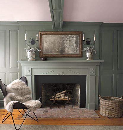 A green-painted living room with matching green mantel and fur throw. A green-painted living room with matching green mantel and fur throw.