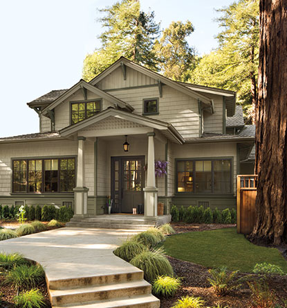 A gray-painted house with green-painted accents and hedges lining the walkway. A gray-painted house with green-painted accents and hedges lining the walkway.