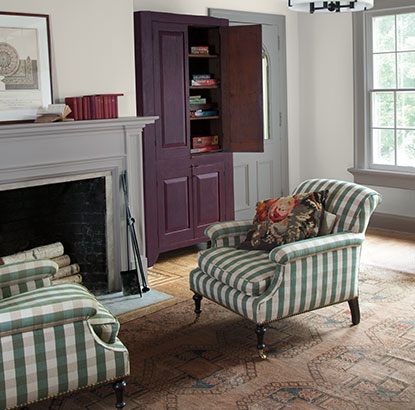 A sitting area with walls painted in Barren Plain 2111-60, fireplace, and two green striped chairs. A sitting area with walls painted in Barren Plain 2111-60, fireplace, and two green striped chairs.