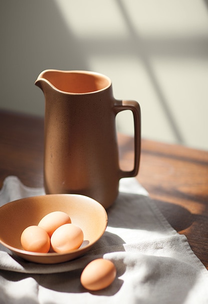 A water jug and bowl of eggs set against a wall painted in Wish AF-680. A water jug and bowl of eggs set against a wall painted in Wish AF-680.