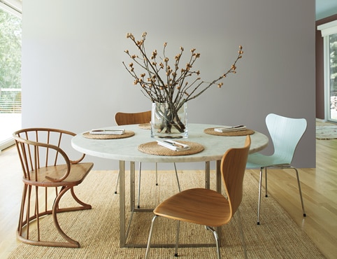 Airy kitchen with gray accent wall and mint ceiling; large paper lantern lighting above circular table with wooden chairs. Airy kitchen with gray accent wall and mint ceiling; large paper lantern lighting above circular table with wooden chairs.
