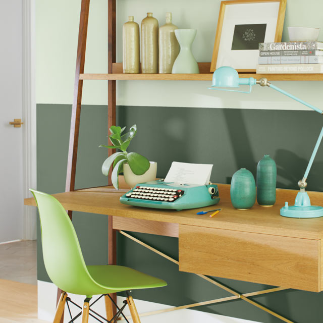 Ce bureau à domicile met en vedette un mur en deux tons de vert et une chaise verte