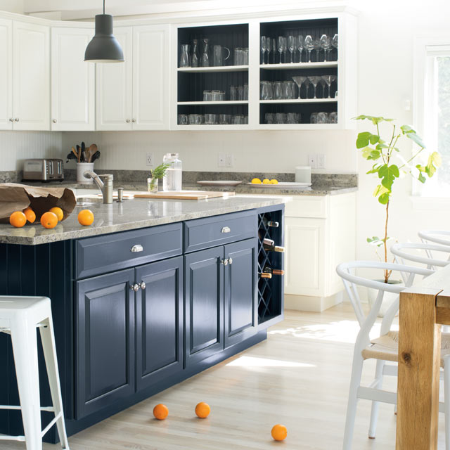 A bright, airy kitchen with blue island and white walls and cabinets