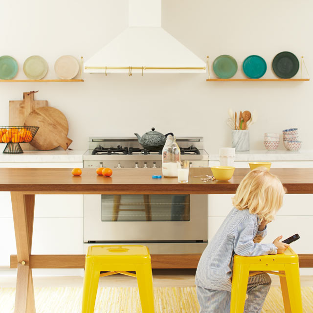 An open, inviting kitchen with neutral walls and bright yellow chairs