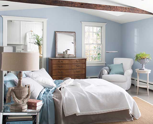 A bedroom with walls painted in Instinct AF-575, displaying the impact of cool paint colors