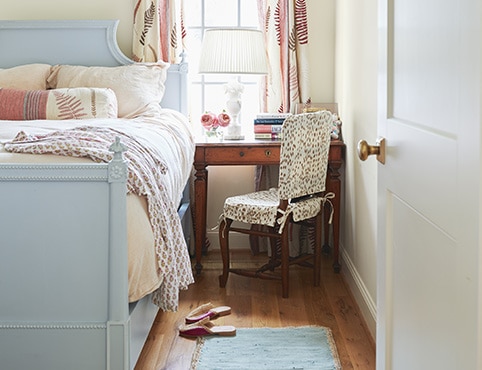 A bedroom with Swiss Coffee painted walls and a blue painted bed frame. A bedroom with Swiss Coffee painted walls and a blue painted bed frame.