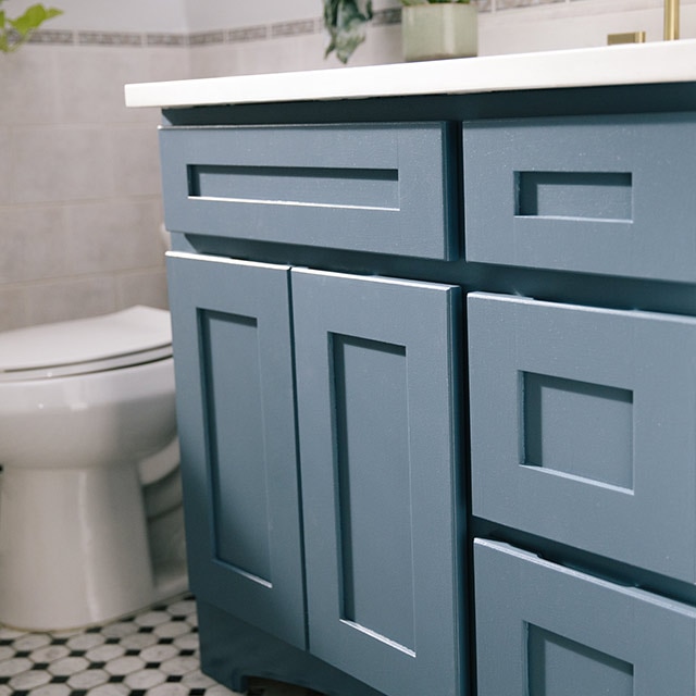 A blue painted bathroom vanity with white countertops. A blue painted bathroom vanity with white countertops.