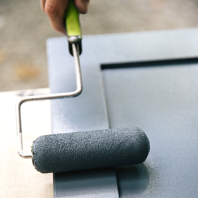 A homeowner painting bathroom cabinets blue using a roller and Benjamin Moore ADVANCE Interior Paint. A homeowner painting bathroom cabinets blue using a roller and Benjamin Moore ADVANCE Interior Paint.