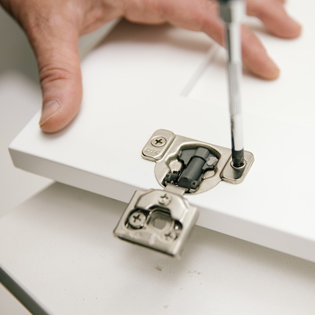 Removing hardware from cabinet frame by using a screwdriver. Removing hardware from cabinet frame by using a screwdriver.