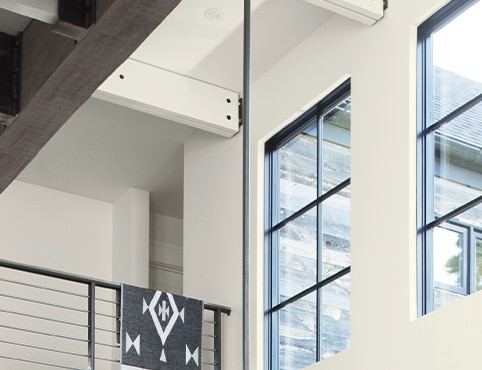A close up of a building with white walls and black trim, focusing on the high walls above stairs. A close up of a building with white walls and black trim, focusing on the high walls above stairs.