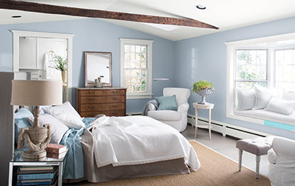Bright bedroom with light blue walls and an exposed wood beam Bright bedroom with light blue walls and an exposed wood beam