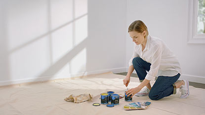 Woman opening paint cans Woman opening paint cans