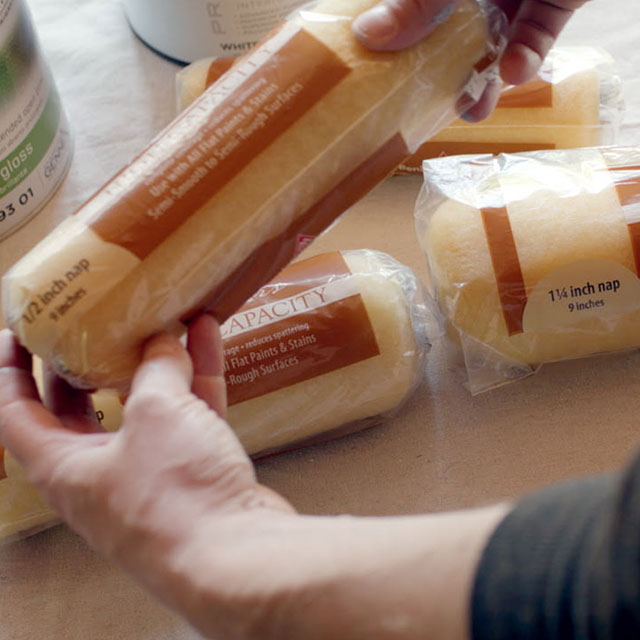A homeowner removing a roller cover from its packaging. A homeowner removing a roller cover from its packaging.