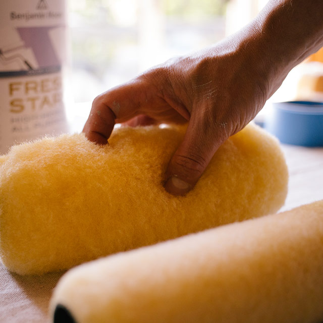A homeowner picking up a roller cover to start their painting project. A homeowner picking up a roller cover to start their painting project.