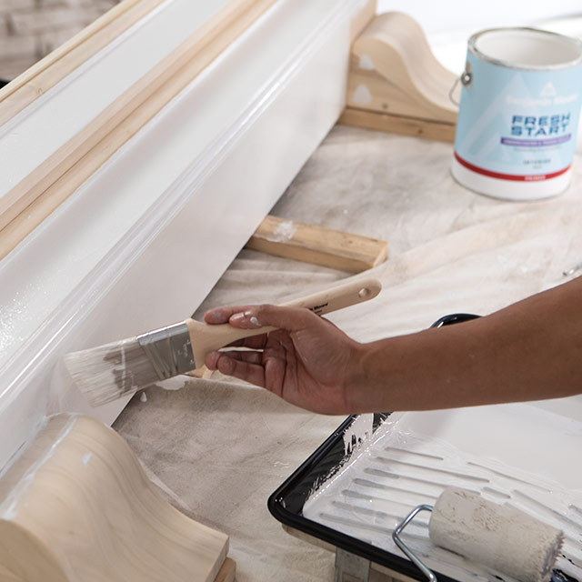 A homeowner using a paintbrush to apply Fresh Start® primer to a floorboard. A homeowner using a paintbrush to apply Fresh Start® primer to a floorboard.