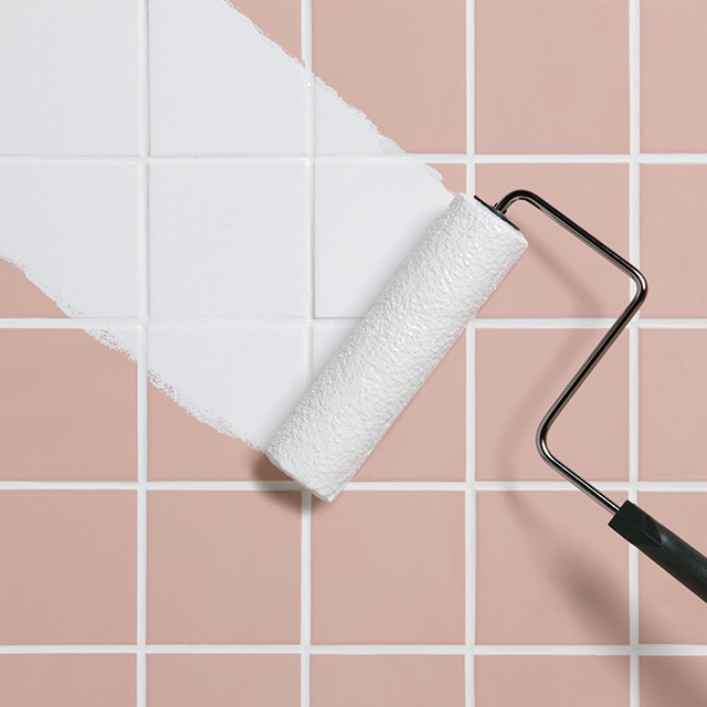Paint roller painting over bathroom tile. Paint roller painting over bathroom tile.